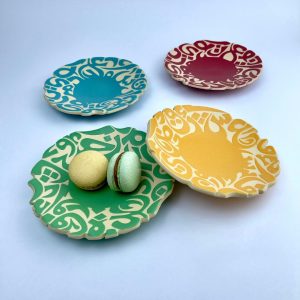 A serving plate featuring a scalloped rim cut calligraphy