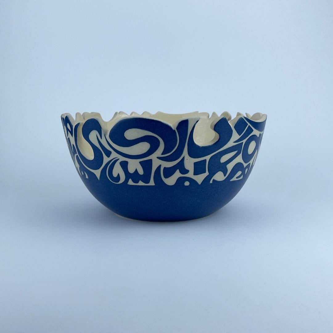 A U-shaped bowl adorned with calligraphy cut edges. Ideal for serving and display.