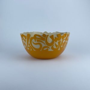 A  U-shaped bowl adorned with calligraphy cut edges. Ideal for serving and display.
