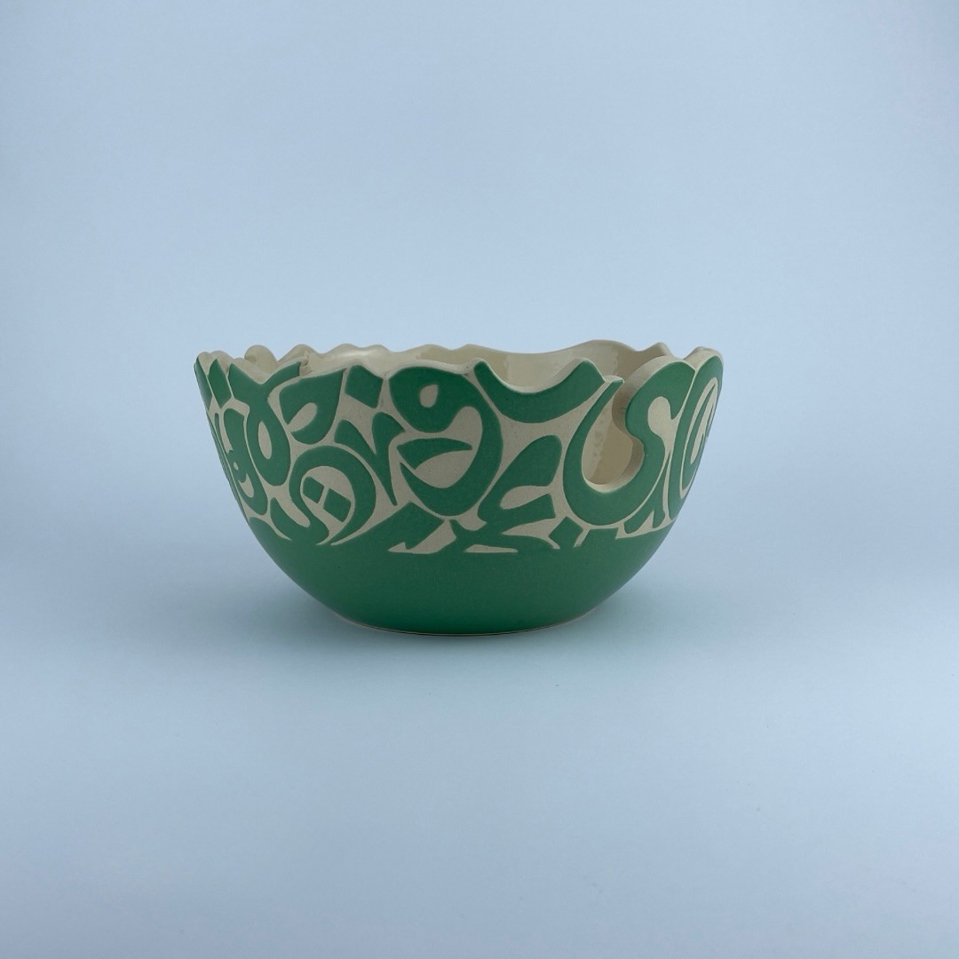 A U-shaped bowl adorned with calligraphy cut edges. Ideal for serving and display.
