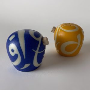 A set of two salt and pepper shakers featuring flowing calligraphic forms
