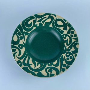 A rimmed plate featuring a scalloped rim with flowing calligraphy motifs