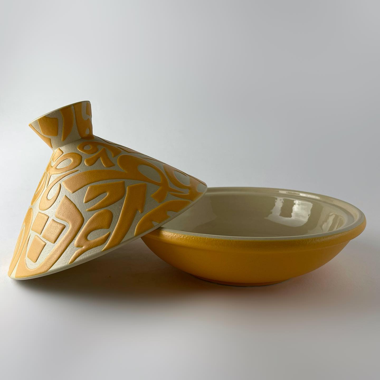 A tajine with a conical lid featuring flowing Arabic calligraphy