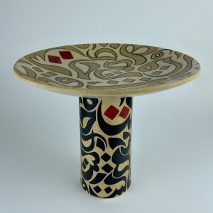 A pedestal plate on a sturdy cylindrical stem featuring contrasting calligraphy
