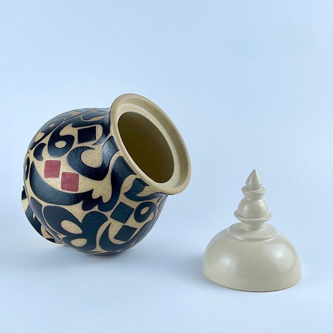 A lidded cookie jar with contrasting calligraphy motifs