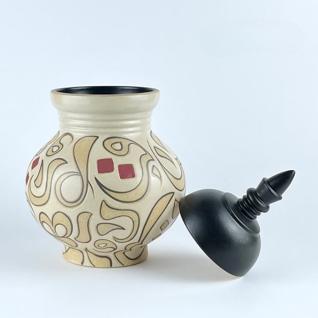 A lidded cookie jar with contrasting calligraphy motifs
