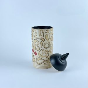 A lidded cylindrical canister with contrasting calligraphy motifs