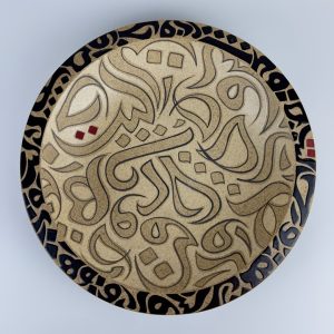 A narrow-rimmed plate featuring black and beige calligraphy