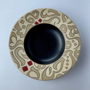 A rimmed plate featuring calligraphy motifs