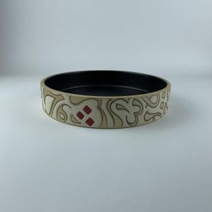 A cylindrical bowl featuring a calligraphy design with flowing beige forms on an earthy background