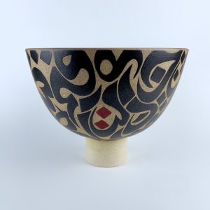 A pedestal bowl on a sturdy foot featuring contrasting calligraphy