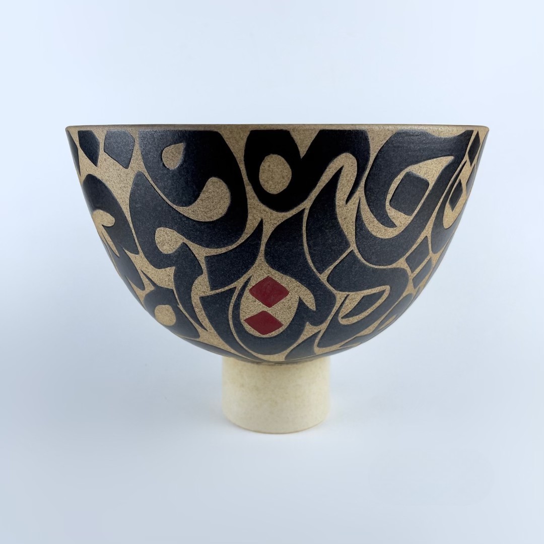 A pedestal bowl on a sturdy foot featuring contrasting calligraphy