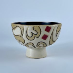 A pedestal nut bowl featuring a calligraphy forms