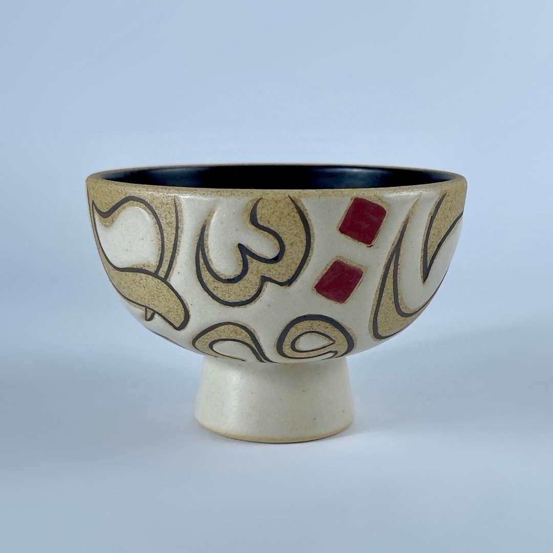 A pedestal nut bowl featuring a calligraphy forms