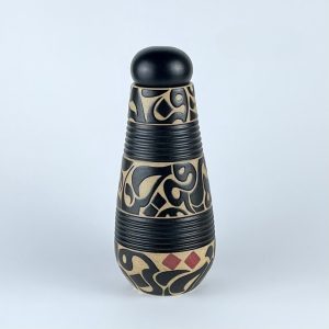 A handleless lidded carafe with flowing black calligraphy on an earthy ground and subtle red dots.