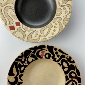 A set of two rimmed plate featuring calligraphy motifs