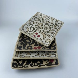 A set of four square plates featuring calligraphy motifs