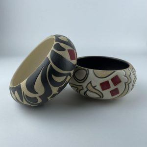 A set of two curved-rim snack bowls featuring contrasting black and beige calligraphy motifs
