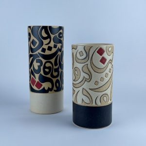 A set of two cylindrical vases featuring contrasting calligraphy motifs