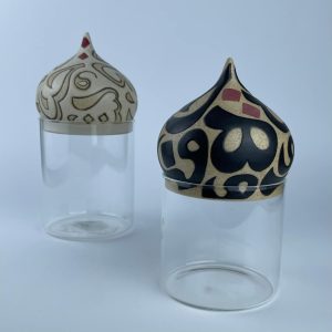 A set of two glass containers with ceramic dome lids