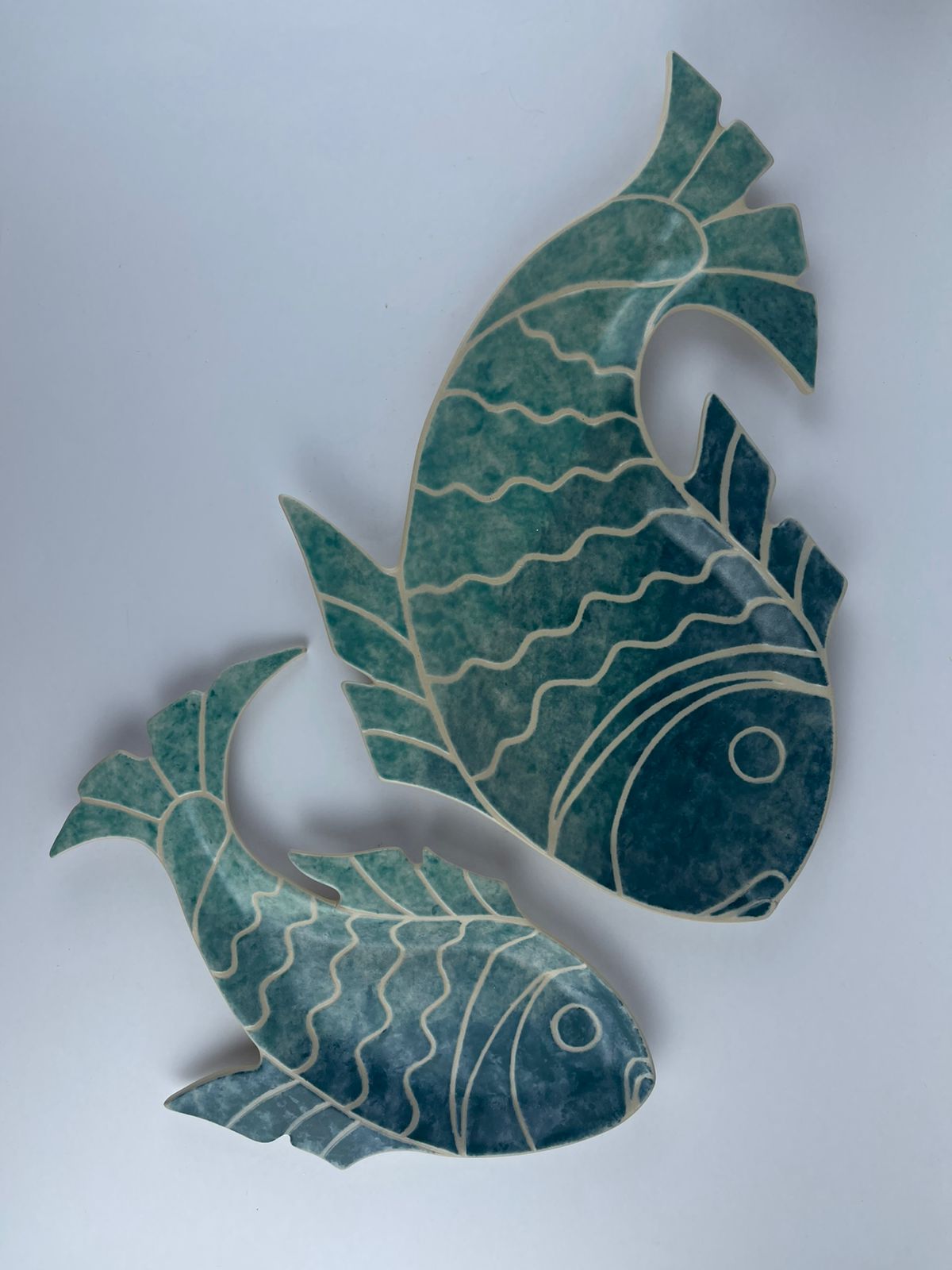 featuring flowing fish swimming through water. Designed for serving food and display.
