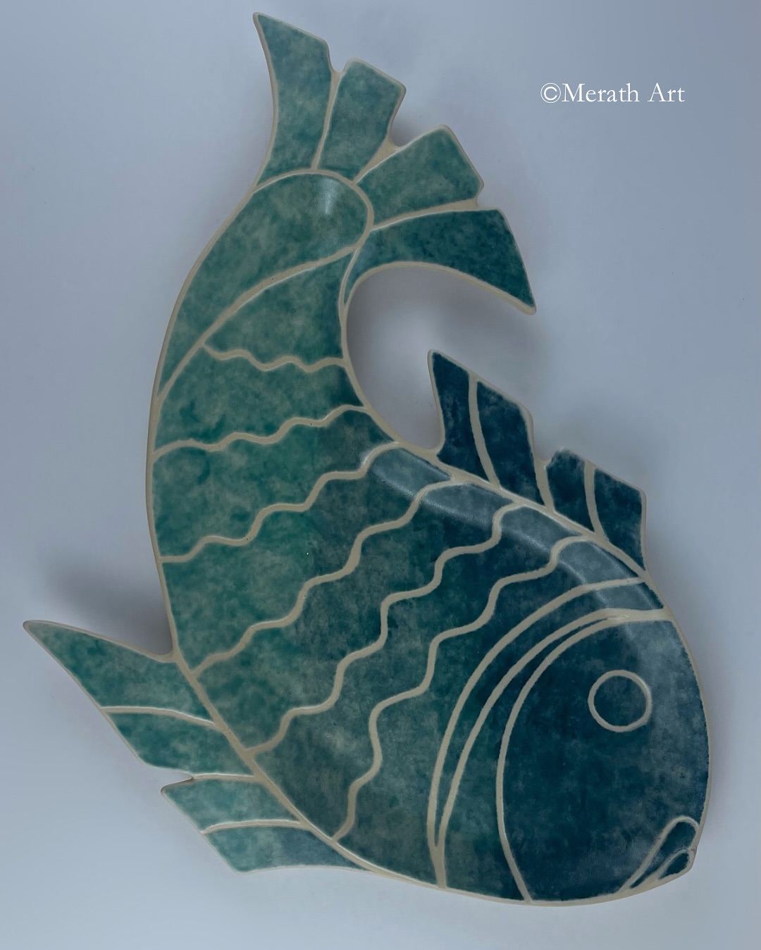A hand-built fish-shaped plate finished with an ombré effect