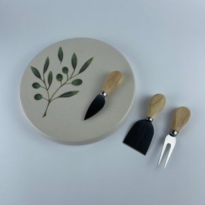 A cylindricalical cheese platter featuring delicate olive branch and leaf motifs on a soft white surface