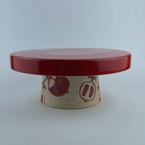 A  lipped cake stand with a glossy red surface