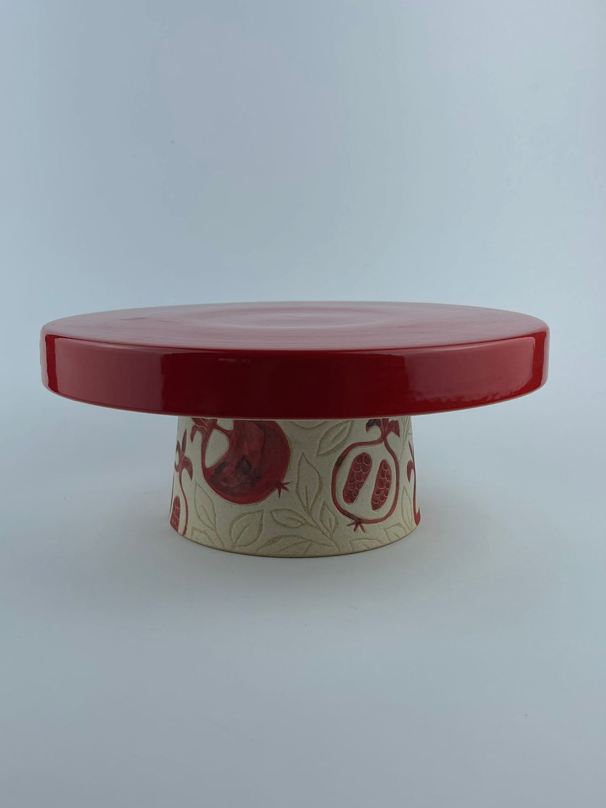 A lipped cake stand with a glossy red surface