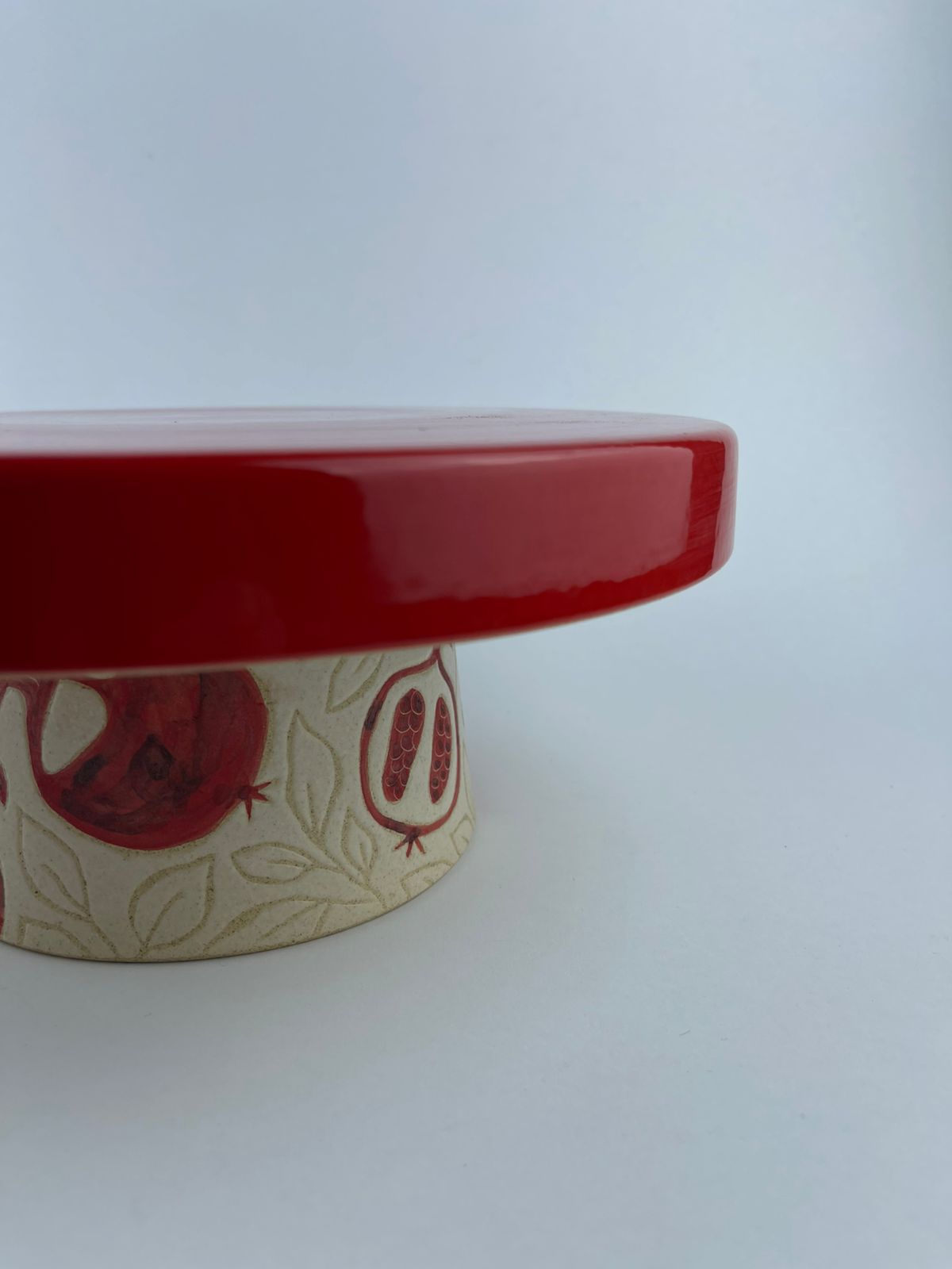 resting on a foot adorned with pomegranate motifs. Designed for serving cakes