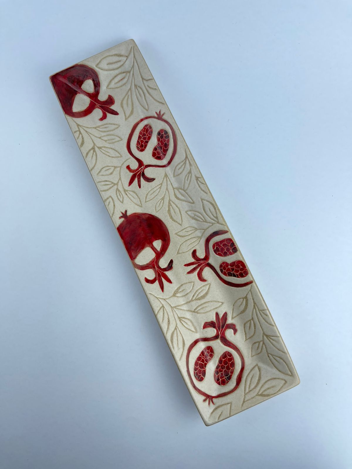 A rectangular appetizer tray featuring pomegranate motifs
