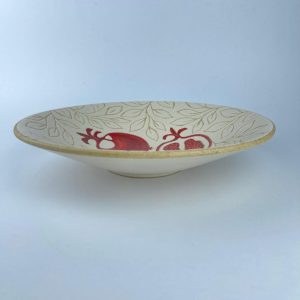 A plate with a red pomegranate motifs. Suitable for serving