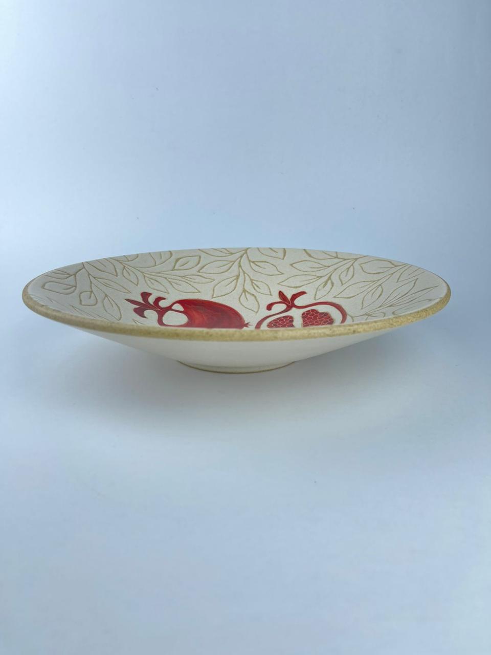 A plate with a red pomegranate motifs. Suitable for serving