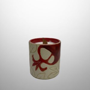 A cylindrical candle vessel featuring pomegranate motifs  with a glossy red interior. Designed for poured candle wax.