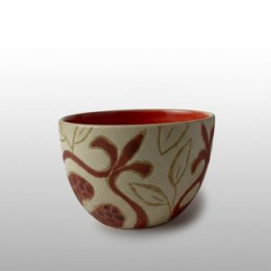 A U-shaped snack bowl featuring red pomegranate motifs