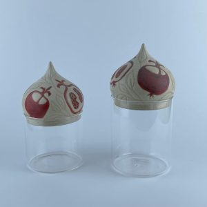 A set of two glass containers with ceramic dome lids
