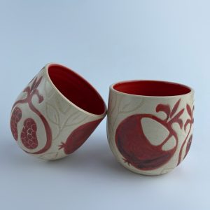 A U-shaped tumbler embellished with a red pomegranate motifs