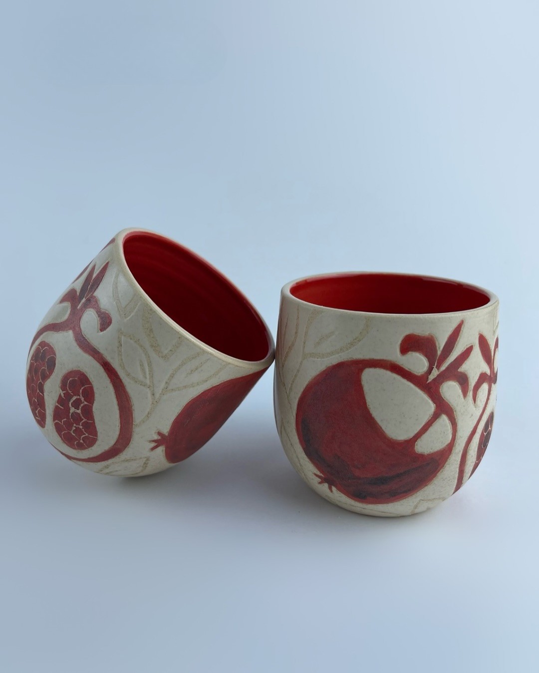 A U-shaped tumbler embellished with a red pomegranate motifs