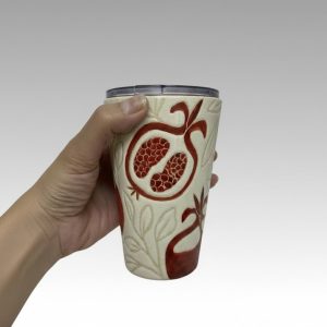 A handleless travel tumbler with a spill-proof lid