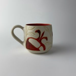 An edged mug featuring a red pomegranate motifs